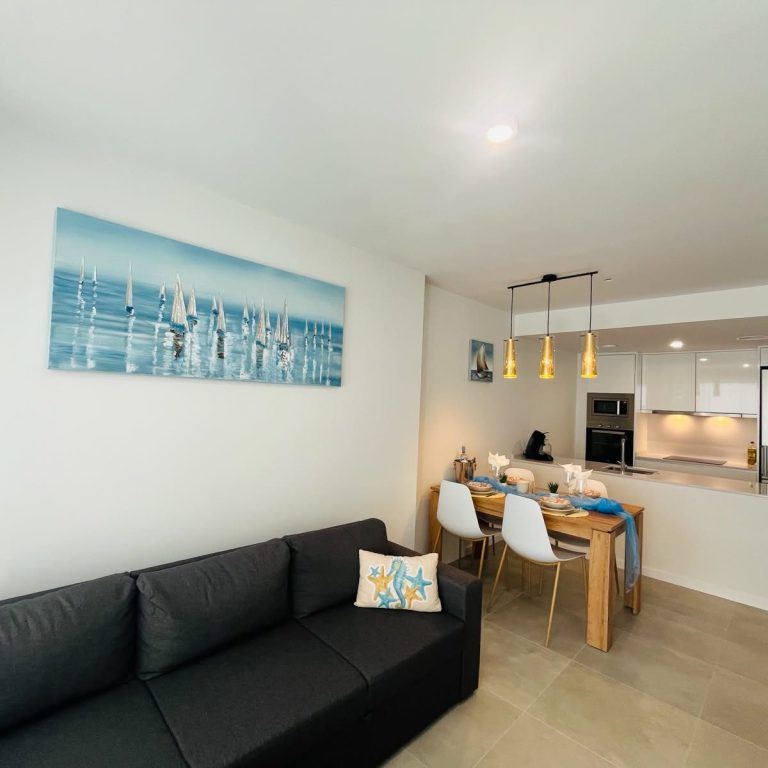 Wohnbereich des Apartments - schwarzes Sofa und ein gedeckter Tisch